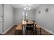 Dining room featuring natural wood floors, dining table with chairs, and a modern light fixture at 10327 Shelter Rock Ct, Charlotte, NC 28214