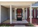 Inviting front porch with a glass-paned red door, sidelights, and red mulch at 10327 Shelter Rock Ct, Charlotte, NC 28214