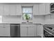 A kitchen featuring white cabinets, stainless steel appliances, and a bright window at 10327 Shelter Rock Ct, Charlotte, NC 28214