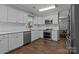 Modern kitchen featuring white cabinets, stainless steel appliances, and wood flooring at 10327 Shelter Rock Ct, Charlotte, NC 28214