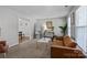 Bright living room with neutral carpet, large windows, and stylish decor at 10327 Shelter Rock Ct, Charlotte, NC 28214