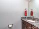 Powder room with granite countertop vanity, red hand towel, and neutral grey paint at 114 Reserve Ln, Fort Mill, SC 29707