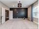 Spacious bonus room with neutral carpet, black accent wall, and stylish modern lighting at 114 Reserve Ln, Fort Mill, SC 29707
