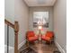 A cute reading nook with a sailboat photo and red chairs sits along the stairway at 114 Reserve Ln, Fort Mill, SC 29707