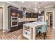 Gourmet kitchen featuring dark wood cabinets, granite island, and stainless steel appliances at 114 Reserve Ln, Fort Mill, SC 29707