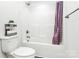 Bright bathroom with a toilet, full white shower and tub combination, and a decorative storage stand on the toilet tank at 1218 Rosada Dr, Charlotte, NC 28213