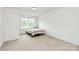 This bedroom features neutral carpet, a window with natural light, and simple furnishings for a cozy atmosphere at 1218 Rosada Dr, Charlotte, NC 28213