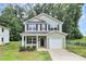 Charming two-story home with light green siding, black shutters, and an attached one car garage at 1218 Rosada Dr, Charlotte, NC 28213