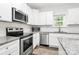 Close-up of a kitchen with stainless steel appliances and white cabinets, perfect for cooking enthusiasts at 1218 Rosada Dr, Charlotte, NC 28213