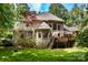 Expansive brick home featuring a wooden deck and well-manicured lawn surrounded by lush trees at 122 Sleepy Cove Trl, Mooresville, NC 28117