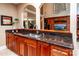 Kitchen wet bar area has wood cabinets, granite countertops, and pass-through to another living area at 122 Sleepy Cove Trl, Mooresville, NC 28117