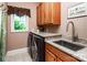 Well-lit laundry room with modern washer and dryer, granite countertops, sink and custom cabinets at 122 Sleepy Cove Trl, Mooresville, NC 28117