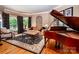 Elegant living room features a baby grand piano and designer curtains at 122 Sleepy Cove Trl, Mooresville, NC 28117