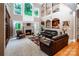 Bright living room with a fireplace, tall windows, and comfortable leather sofas for relaxation at 122 Sleepy Cove Trl, Mooresville, NC 28117