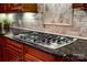 Close up of kitchen gas cook top with granite countertops and backsplash at 122 Sleepy Cove Trl, Mooresville, NC 28117