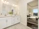 Modern bathroom with double vanity and tile flooring, connected to bedroom space at 125 Noah Ln, Troutman, NC 28166