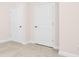 Bedroom corner with two doors, neutral carpet, and white trim at 125 Noah Ln, Troutman, NC 28166