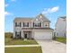 Charming two-story home with a well-manicured lawn, attached garage and inviting front porch at 1433 Harleston St, Indian Trail, NC 28079