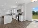 Open concept kitchen with stainless steel appliances, white cabinetry, island and adjacent sliding doors to backyard at 1433 Harleston St, Indian Trail, NC 28079