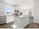 Modern kitchen with stainless steel appliances, kitchen island, white cabinets and light-filled adjacent dining area at 1433 Harleston St, Indian Trail, NC 28079