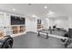 Basement home gym and entertainment area including exercise equipment and shelving with storage baskets at 1550 Queens W Rd, Charlotte, NC 28207