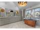 Stunning bathroom with a standalone copper tub, dual vanities, and contemporary lighting fixtures at 1550 Queens W Rd, Charlotte, NC 28207