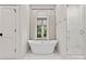Bright bathroom featuring a modern freestanding tub with a window view and a separate glass-enclosed shower at 1550 Queens W Rd, Charlotte, NC 28207