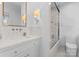 Bright bathroom featuring marble countertops, herringbone tile, and glass enclosed shower with a soaking tub at 1550 Queens W Rd, Charlotte, NC 28207