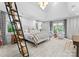 Spacious bedroom with large windows, cozy seating, and ladder access to an upper level at 1550 Queens W Rd, Charlotte, NC 28207