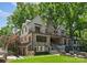 Impressive exterior elevation of home with stone accents, balconies, and a well-maintained yard with a pool at 1550 Queens W Rd, Charlotte, NC 28207