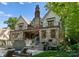 Back exterior featuring stone facade, multiple balconies, outdoor seating, and lush landscaping at 1550 Queens W Rd, Charlotte, NC 28207