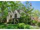 A charming Tudor-style home with stone and ivy accents nestled amongst mature trees at 1550 Queens W Rd, Charlotte, NC 28207