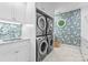 Well-appointed laundry room featuring a modern washer and dryer, stylish wallpaper, and ample storage at 1550 Queens W Rd, Charlotte, NC 28207