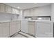 Well-equipped laundry room with modern appliances, ample counter space, and custom cabinetry at 1550 Queens W Rd, Charlotte, NC 28207
