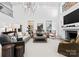 Bright living room with high ceilings, elegant chandelier, stone fireplace, and comfortable seating for a welcoming atmosphere at 1550 Queens W Rd, Charlotte, NC 28207
