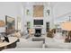Bright living room with a stone fireplace, high ceilings, and large windows that fill the room with light at 1550 Queens W Rd, Charlotte, NC 28207