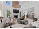 Spacious living room featuring a stone fireplace, large windows, and open-concept design with a view into the kitchen at 1550 Queens W Rd, Charlotte, NC 28207