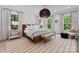 Spacious main bedroom featuring large windows, a comfortable bed, stylish lighting, and chic decor at 1550 Queens W Rd, Charlotte, NC 28207
