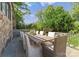 Outdoor dining area featuring a stone patio, an elegant wood table, and lush landscaping, perfect for entertaining at 1550 Queens W Rd, Charlotte, NC 28207