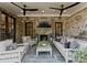 Outdoor living area with stone fireplace, comfortable seating, ceiling fans, and an entertainment center at 1550 Queens W Rd, Charlotte, NC 28207