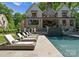 Stunning backyard pool with stone patio, lounge chairs, and elegant exterior of the home at 1550 Queens W Rd, Charlotte, NC 28207