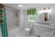 Bathroom featuring a tub/shower, toilet, vanity and a window with views of the outdoors at 1567 Jennings Rd, Statesville, NC 28625