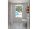Bright bathroom featuring a shower, toilet, and a window overlooking the pool area at 1567 Jennings Rd, Statesville, NC 28625