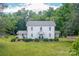 Charming two-story white home with lush green lawn and mature trees, creating a serene and inviting setting at 1567 Jennings Rd, Statesville, NC 28625