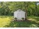 Quaint backyard shed surrounded by lush greenery and mature trees at 1567 Jennings Rd, Statesville, NC 28625