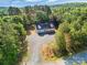 An elevated view shows home surrounded by trees and large gravel driveway at 1811 Continental Dr, Albemarle, NC 28001