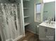 Bright bathroom with a shower and tub combination, plus built-in shelving for storage at 189 6Th Ave, New London, NC 28127
