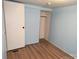 Bedroom with light blue walls, wood floors and closet at 189 6Th Ave, New London, NC 28127