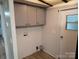 A well-lit laundry room offers convenience with overhead cabinets and washer-dryer hookups at 189 6Th Ave, New London, NC 28127