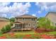Beautifully landscaped backyard featuring a spacious deck, patio area, and lush greenery at 1919 Madeira Cir, Waxhaw, NC 28173